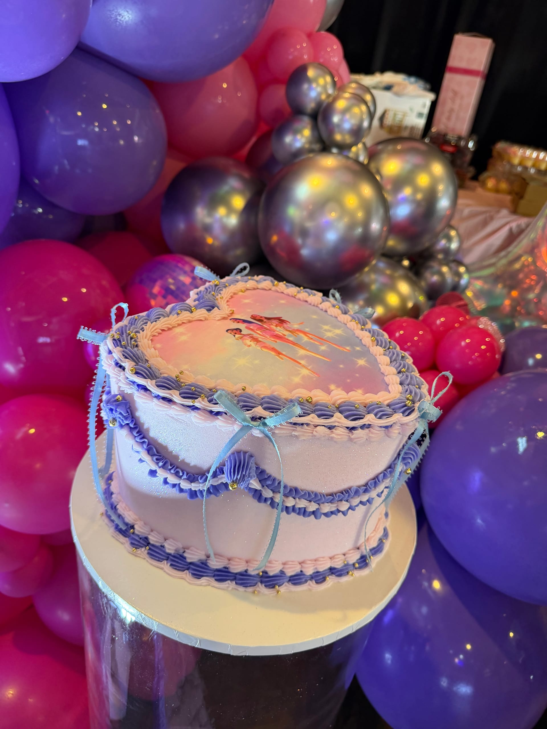 Custom birthday cake surrounded by colorful balloon display