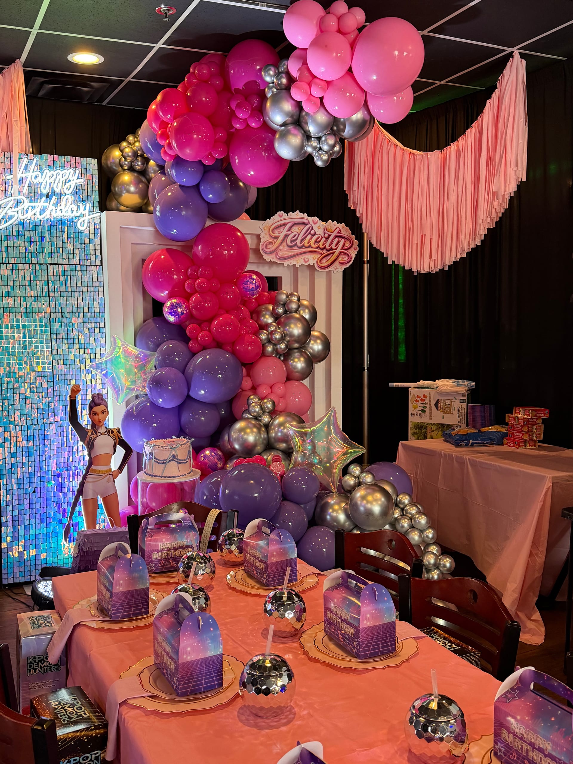 Complete birthday party setup with balloon arch, decorated tables, and personalized backdrop at World Food Trucks